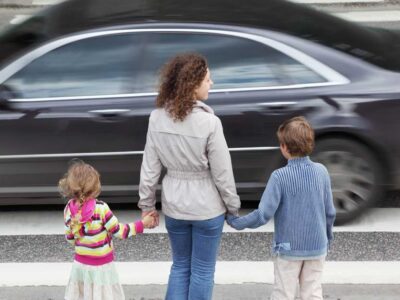 mamma med barn väntar vid övergångsställe